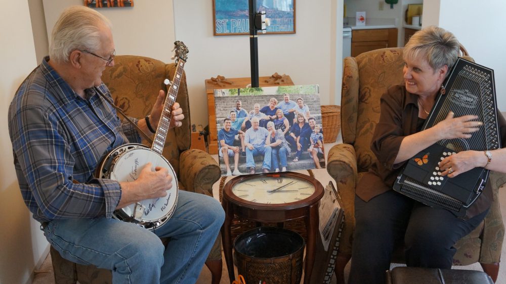 Image of husband and wife residents playing musical instruments together