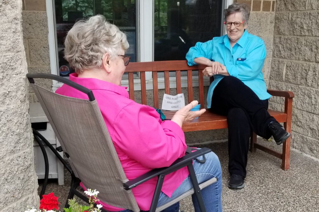 Image of two residents socializing on patio